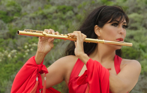 Flutist Viviana Guzman in red dress playing gold flute