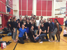 A dance class posing together in the gym before a performance