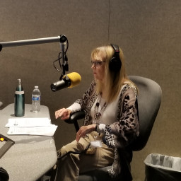 Faculty member Linda Collins sitting in chair with a microphone in front of her