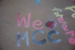 Chalk drawing on sidewalk that says We love MCC