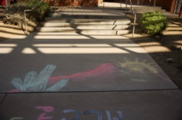 Chalk drawing on sidewalk of a cactus, mountain, and sun