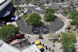 Aerial view of people standing in shape of 60.