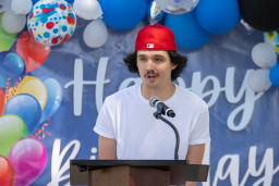 Student wearing red baseball cap speaking at podium