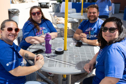 Guests sitting at picnic table all wearing Feel the Thunder tshirts