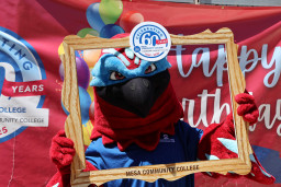 MCC mascot, Thor, holding picture frame in front of birthday sign