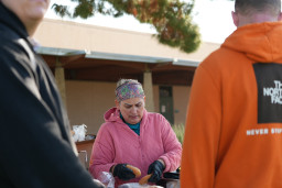 Person in pink sweatshirt holding a hamburger bun