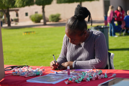 Woman in sweater sitting at a table with Dum Dum suckers
