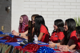 Several team members of MCC's Cross County team sitting at table signing photos