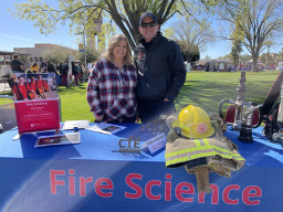 Hans Silberschlag, faculty in Fire Science standing with a woman at a table
