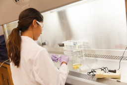Student in white coat and safety glasses in science class