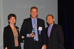 MCC Hall of Fame inductee Keith Ballard is congratulated on stage by Alumni Relations Coordinator Marcy Snitzer and MCC President Dr. Shouan Pan.