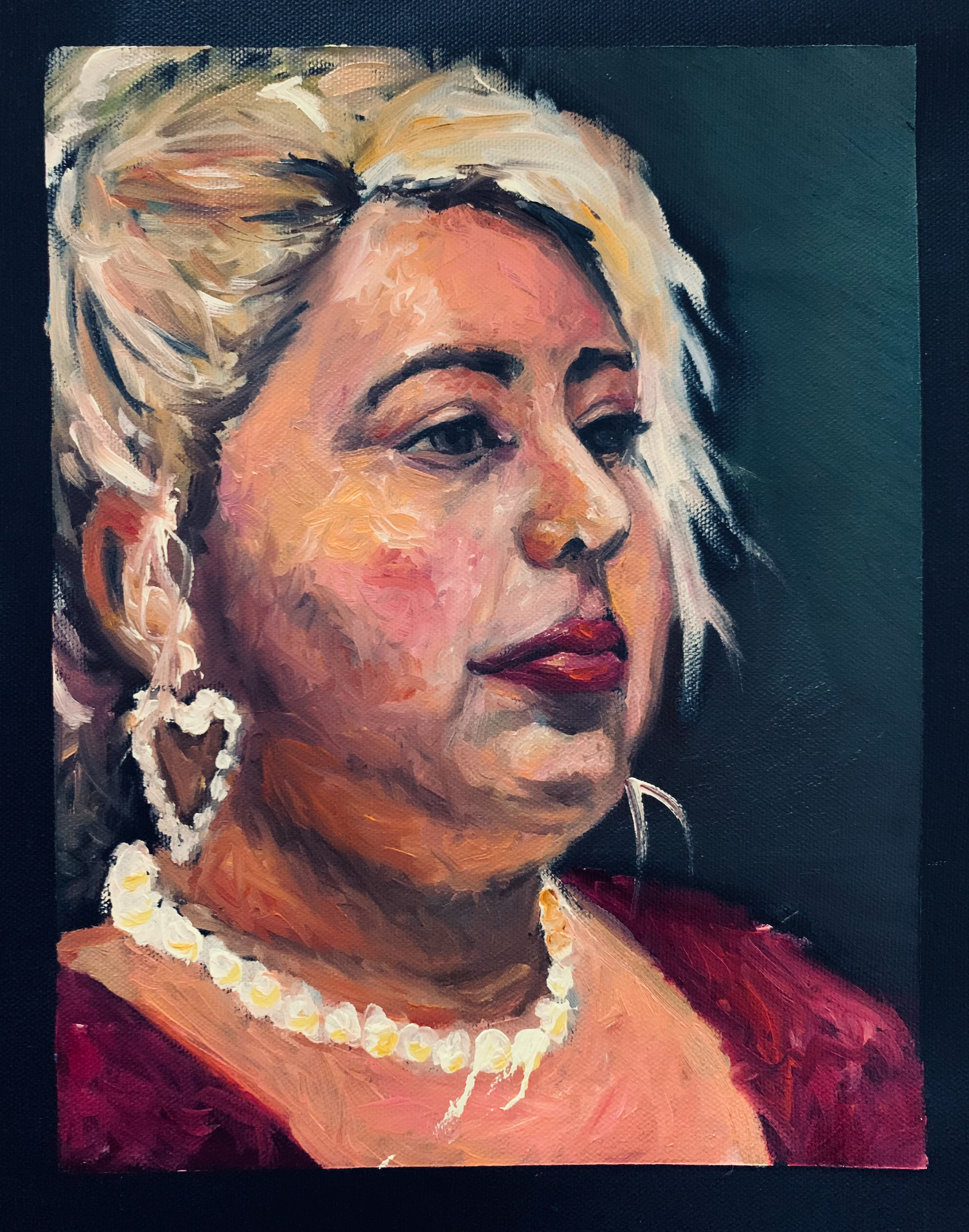 Portrait of a woman with blonde hair and pearl jewelry.
