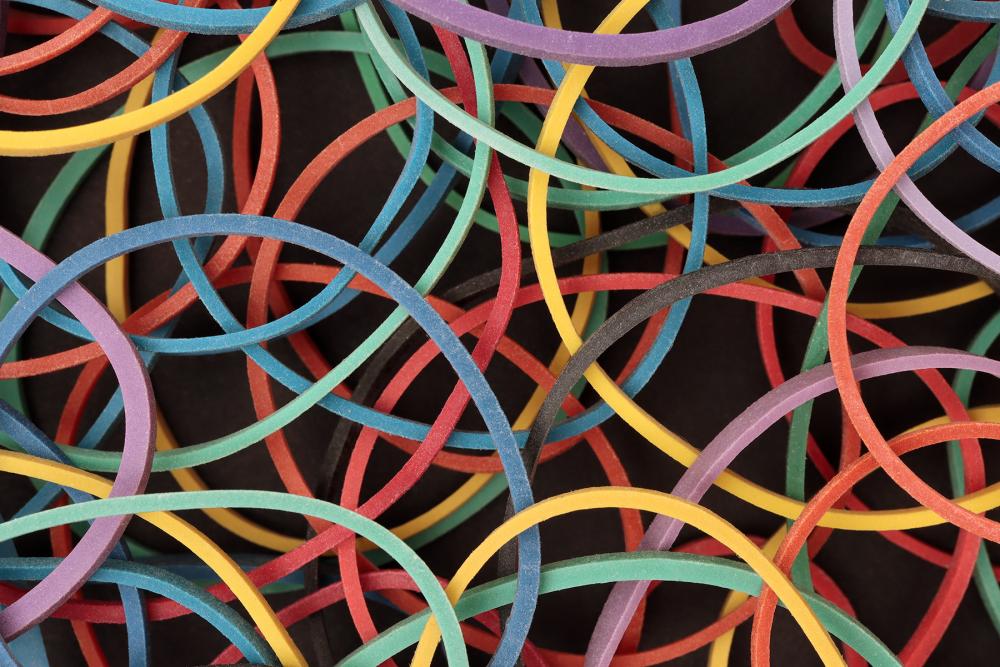 Photograph of colored rubber bands on a dark background.