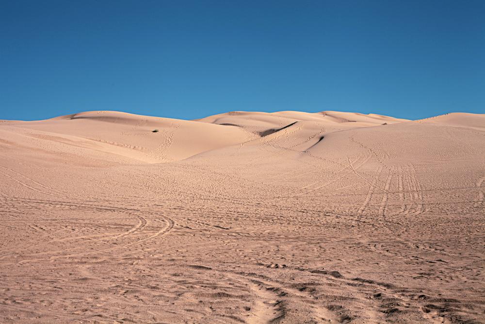 A photograph of sand dunes on the horizon.