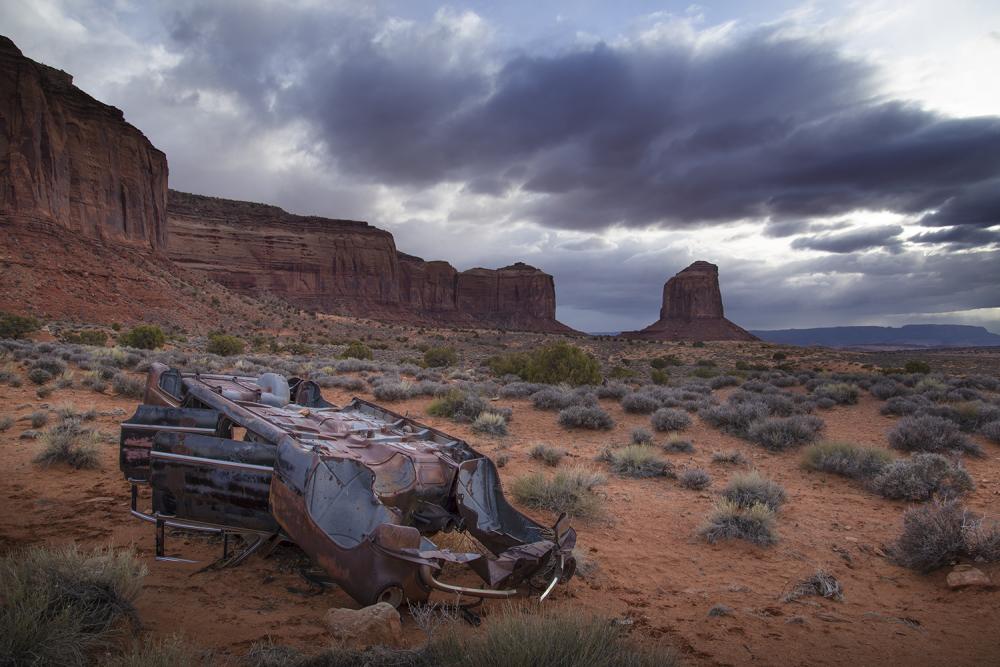 Photograph of an abandoned car in Monument Valley.