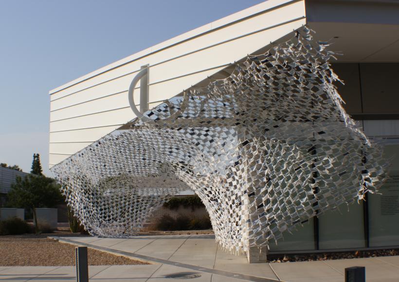 Installation view of Wave by artists Debra Everett and Ronna Nemitz. Over 2000 handmade masks blow in the wind on the exterior of MCC Art Gallery.