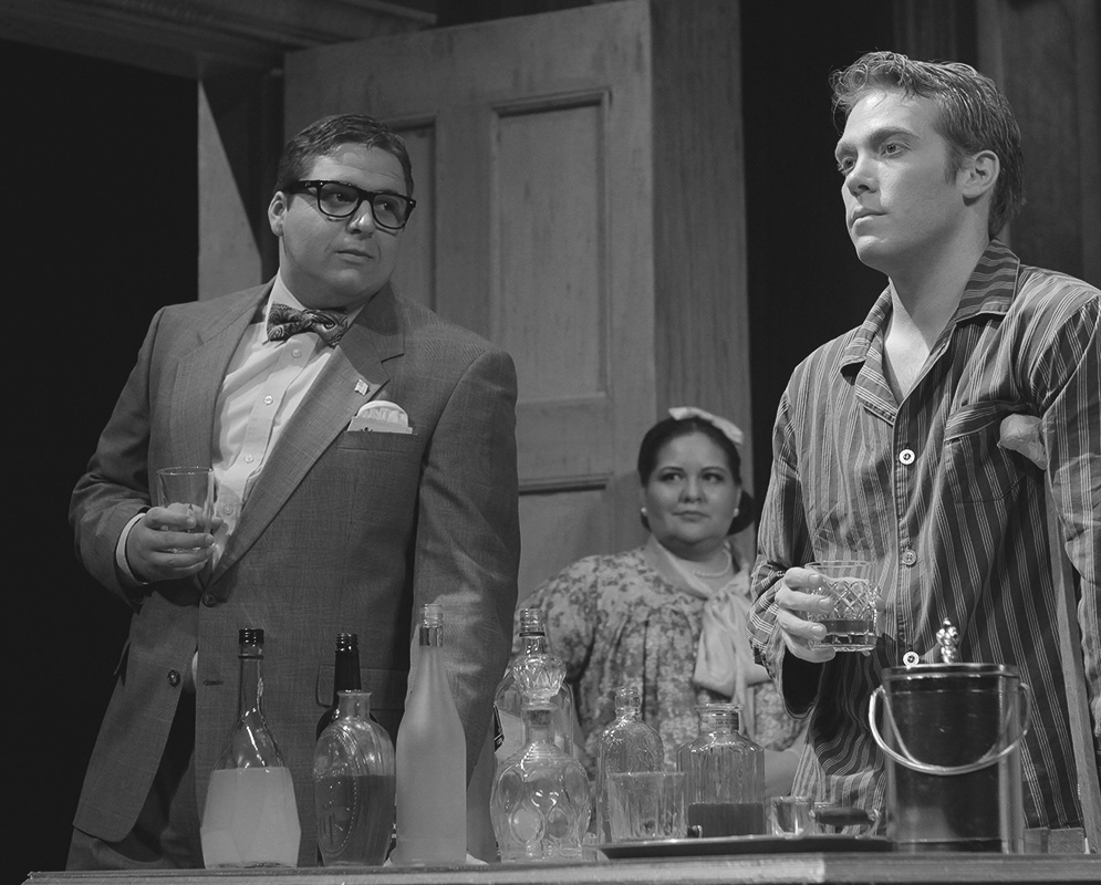 Three actors performing in play with drinking glasses.