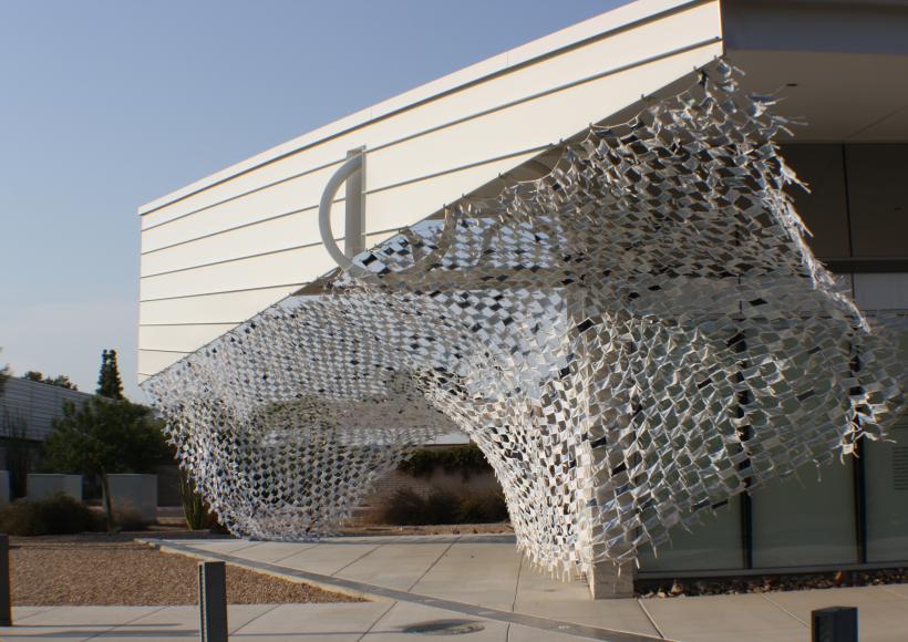 Installation view of Wave by artists Debra Everett and Ronna Nemitz. Over 2000 handmade masks blow in the wind on the exterior of MCC Art Gallery.