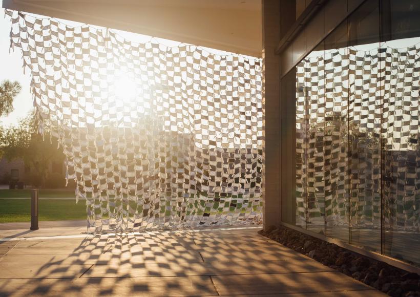 Installation view of Wave by artists Debra Everett and Ronna Nemitz. Over 2000 handmade masks blow in the wind on the exterior of MCC Art Gallery.