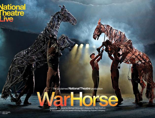 Two life sized war horse puppets on stage with five puppeteer operators on stage