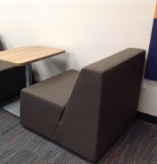 Chairs and a table provide soft seating for students working as a pair
