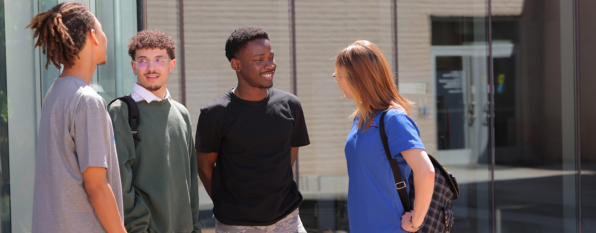 Four students in front of the Enrollment Center
