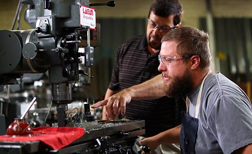 two people working on a machine