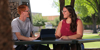 Two students sitting outside.