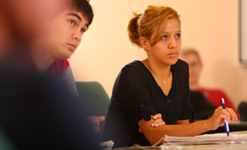Two students in a classroom looking forward.