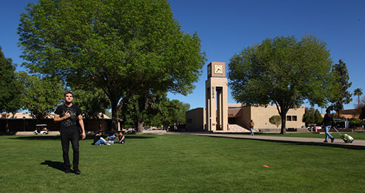 A large lawn on the MCC campus with the clock tower in view