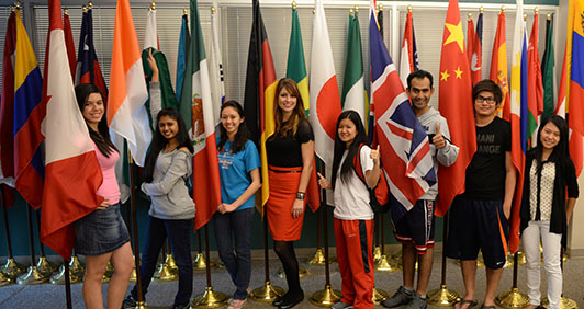 A group of international students posing with national flags