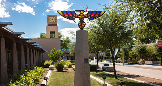 The Thunderbird statue on campus with the clock tower behind