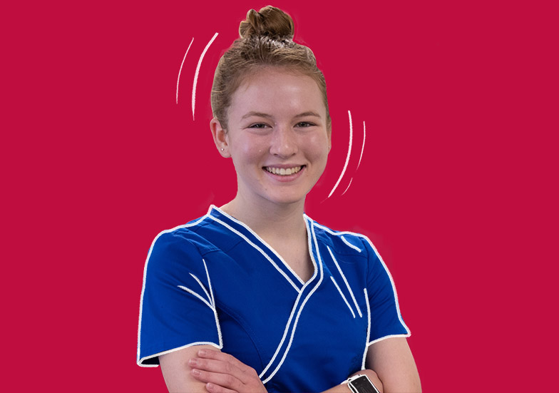 A female nursing student in scrubs on a solid background