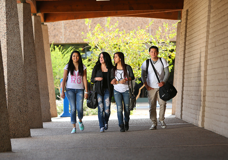 Four students walking across campus