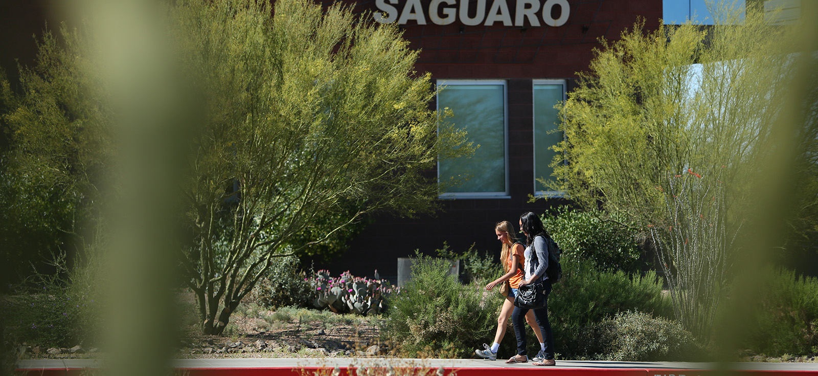 Two students walking across the MCC Red Mountain Campus