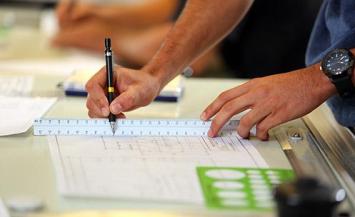 Person using ruler on blueprint