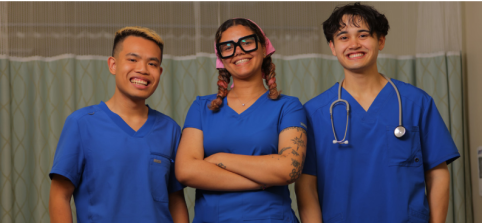 Three students posing in scrubs, one with a stethoscope.