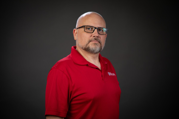 Headshot of Bryan in a red polo shirt.