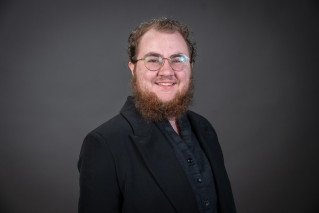 Leonardo Warnick wearing glasses and a black blazer