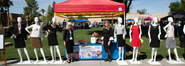 Alumni board members pose with mannequins at Dress for Success booth