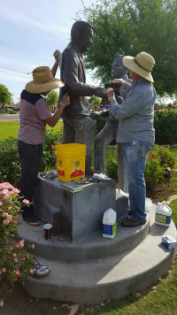 Two people working on statue