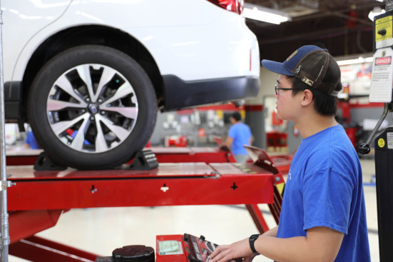 Student looking at SUV tire