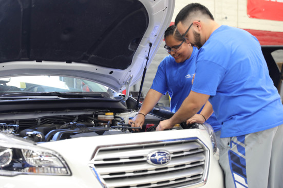 Two students looking at SUV engine