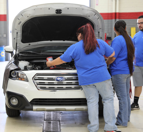 Students using diagnostic tools on Subaru Outback engine