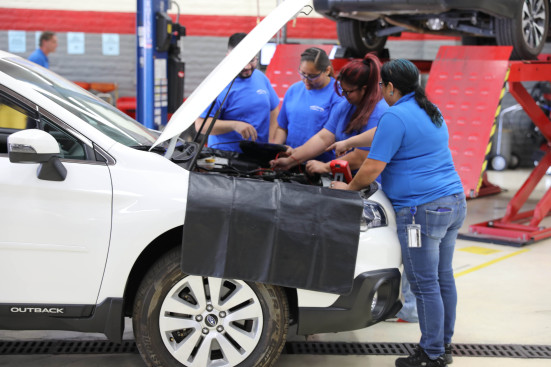Students using diagnostic tools on Subaru Outback engine