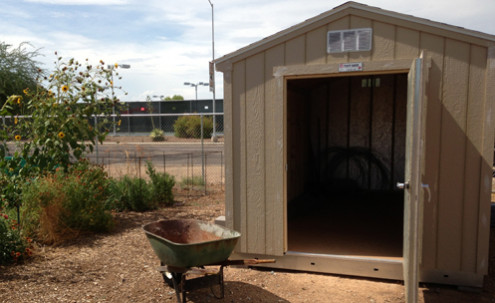 A small shed and wheelbarrow.