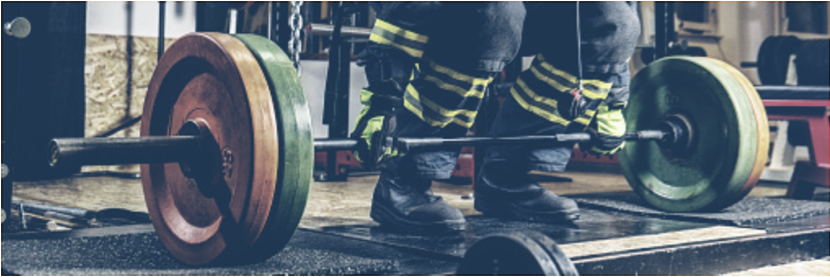 Someone in firefighting gear deadlifts a weight bar.