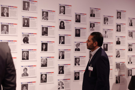 A man in a suit looking a the Hall of Fame exhibit on the wall