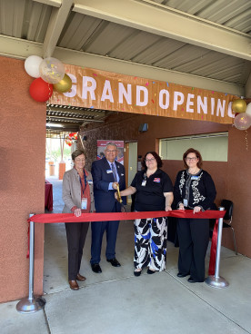 MCC Employees standing in front of a ribbon cutting for a grand opening