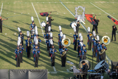 Large group of students with instruments on a grass field